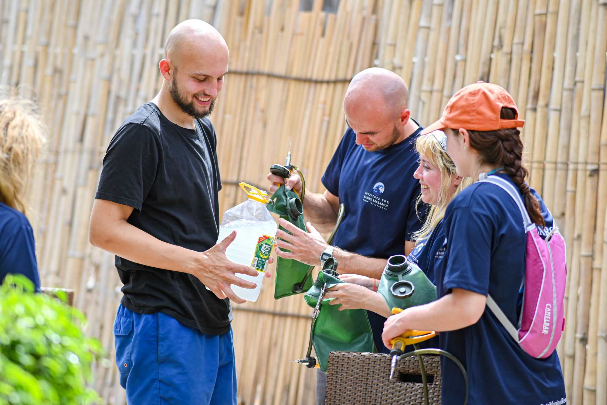 A picture of 4 people filling bags with vinegar