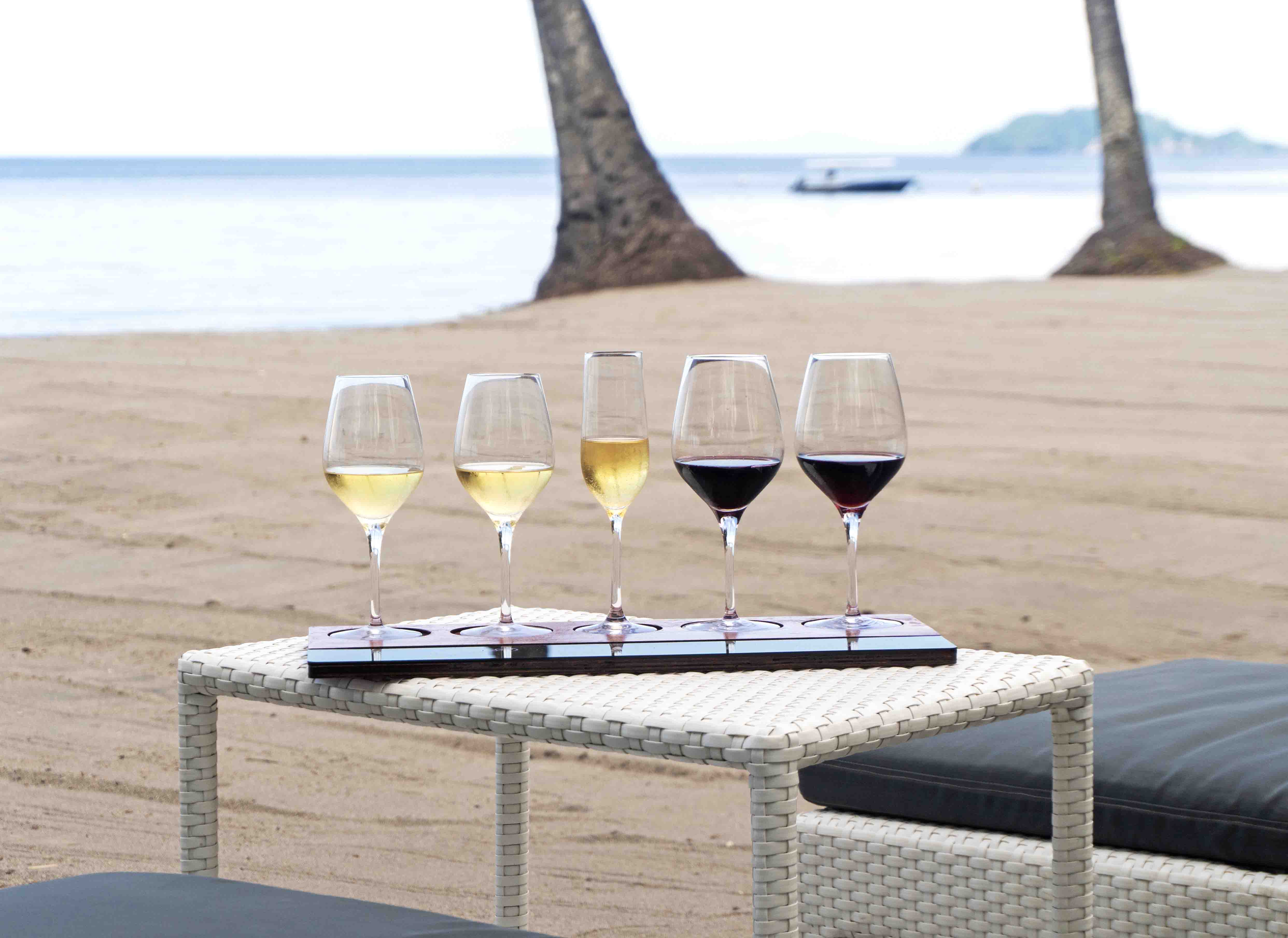 White and red wine on a wine flight on the beach in the Philippines at Atmosphere Resorts & Spa.